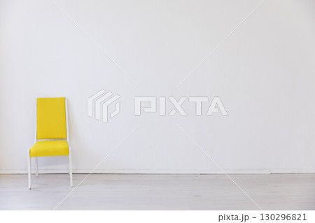 Yellow chair in the interior of an empty white room 130296821