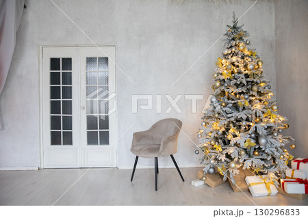 Christmas Tree with Gifts Decorated with Garlands and Toys in White Room Interior Christmas Tree with Gifts Decorated with Garlands and Toys in White Room Interior 130296833