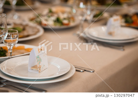 Elegant Wedding Table Setting with Favor Boxes. Fine Dining. Light Brown Colors. Plates. Glasses. Festive Celebration. Gift. Banquet Decor. Detail Shot Elegant Wedding Table Setting with Favor Boxes. Fine Dining. Light Brown Colors. Plates. Glasses. Festive Celebration. Gift. Banquet Decor. Detail Shot 130297047