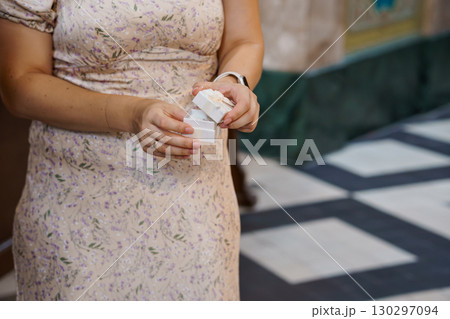 Woman Holding Open Ring Box. Floral Dress. Engagement. Gift. Proposal. Pink. Close-Up. Romance. Jewelry. Hands. Celebration. Love. Delicate. 130297094