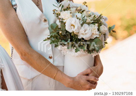 Elegant Bride Holding White Bouquet With Eucalyptus, Wedding Flowers, Sunlight, Ceremony, Formal Attire, Romantic Gesture, Ivory Dress, Nature View Elegant Bride Holding White Bouquet With Eucalyptus, Wedding Flowers, Sunlight, Ceremony, Formal Attire, Romantic Gesture, Ivory Dress, Nature View 130297108