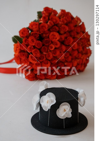 Vibrant Red Roses Bouquet and Black Top Hat Cake. Romantic Gift Idea, Floral Arrangement, Love, Celebration, Anniversary, Rich Colors, Stylish Design Vibrant Red Roses Bouquet and Black Top Hat Cake. Romantic Gift Idea, Floral Arrangement, Love, Celebration, Anniversary, Rich Colors, Stylish Design 130297114