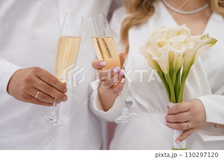 Romantic Wedding Celebration Toast with Champagne and White Callas, Close-Up Elegant Love, Luxury, Partnership, White Flowers, Golden Bubbles. 130297120