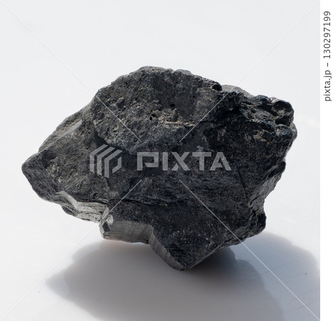 Raw Black Tourmaline Crystal Rock Specimen Isolated on White: Dark Stone Texture, Volcanic Mineral, Gemstone, Natural Lighting, Studio Shot 130297199