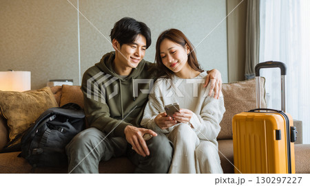自宅で旅行計画を立てる夫婦 130297227
