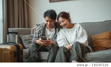 自宅で旅行計画を立てる夫婦 130297228