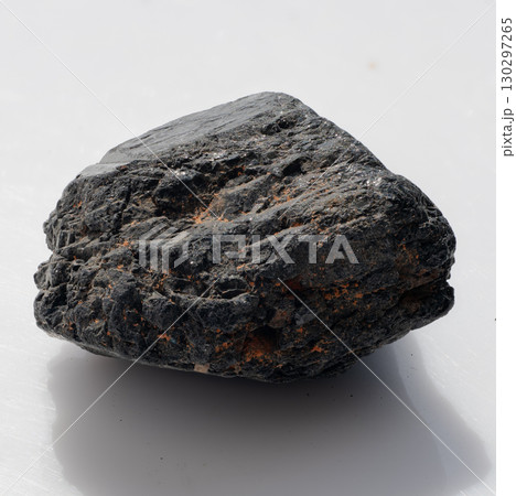 Polished Black Tourmaline Crystal Stone on White Background. Dark Mineral Specimen, Natural Gemstone, Jewelry Making, Healing Crystals, Textural Detail 130297265