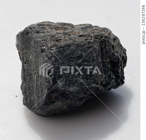 Raw Black Tourmaline Crystal Specimen Isolated on White. Dark Mineral with Striations, Rough Texture, Protective Stone, Natural Gemstone 130297266