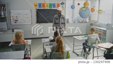 Engineer in Uniform Giving Lecture to Curious Primary School Students About Construction Process 130297406