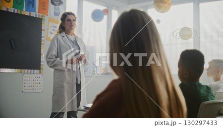 Female Doctor Visiting Classroom, Giving Lecture to Curious Primary School Students About Health and Hygiene Female Doctor Visiting Classroom, Giving Lecture to Curious Primary School Students About Health and Hygiene 130297433