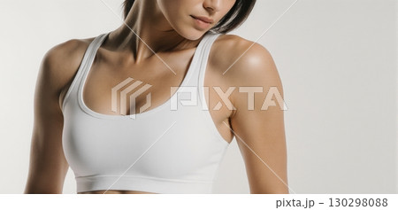 Woman in white sports bra posing for activewear and fitness fashion concept 130298088