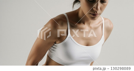 Woman in white sports bra posing for activewear and fitness fashion concept 130298089
