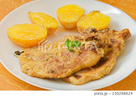 Pork meat with mustard and potatoes on plate 130298624