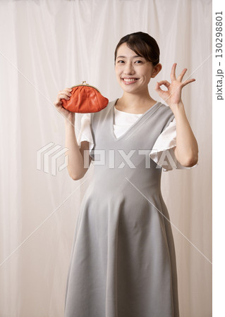 赤い財布を持って微笑む妊娠8ヶ月の女性 赤い財布を持って微笑む妊娠8ヶ月の女性 130298801