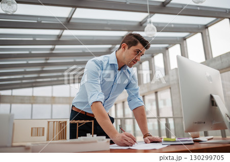 Young businessman, engineer working in office, working on plan or technical document. 130299705
