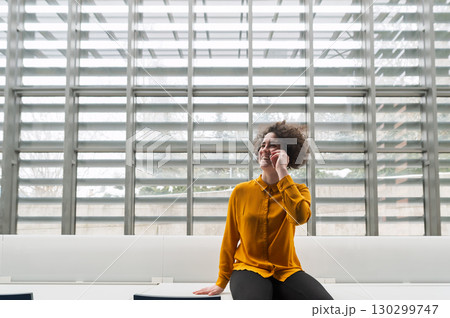 Woman making phone call in modern office. Woman making phone call in modern office. 130299747