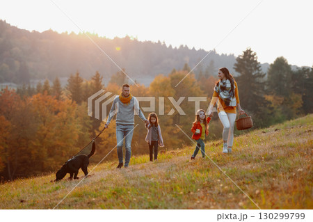 A portrait of young family with two small children in autumn nature at sunset. 130299799
