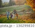 A portrait of young family with two small children in autumn nature at sunset. 130299810