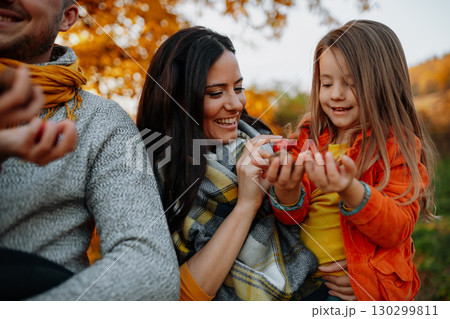 A portrait of young family with two small children in autumn nature at sunset. 130299811