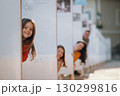 Potrait of girl with family having peek from behind a panels. 130299816