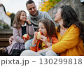 Sisters and parents in park during warm autumn day. 130299818