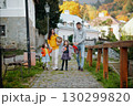 Sisters and parents walking in park during warm autumn day. 130299820