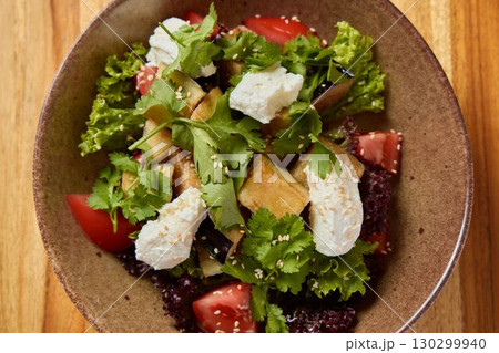 Indulge in a Fresh Garden Salad featuring delicious Creamy Toppings and crunchy Sesame Seeds 130299940