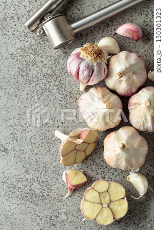 Garlic and garlic press on a kitchen table. Garlic and garlic press on a kitchen table. 130301323