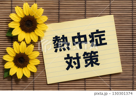 暑い夏に必須の熱中症対策の文字が書かれたメモ用紙と明るいひまわりの画像 暑い夏に必須の熱中症対策の文字が書かれたメモ用紙と明るいひまわりの画像 130301374