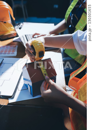 Closeup of team of industrial engineers meeting analyze machinery blueprints consult project on table in manufacturing factory. Working in manufacturing plant or production plant. 130301655