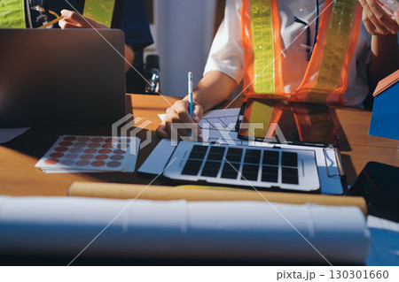 Closeup of team of industrial engineers meeting analyze machinery blueprints consult project on table in manufacturing factory. Working in manufacturing plant or production plant. Closeup of team of industrial engineers meeting analyze machinery blueprints consult project on table in manufacturing factory. Working in manufacturing plant or production plant. 130301660