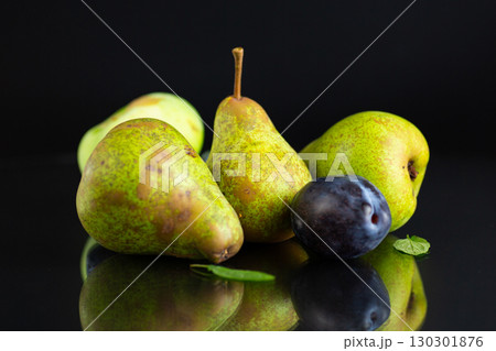 Ripe pears and plums on a black background 130301876