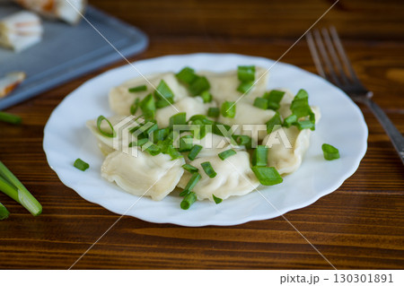 Appetizing dumplings with potatoes and onions on a rustic table 130301891