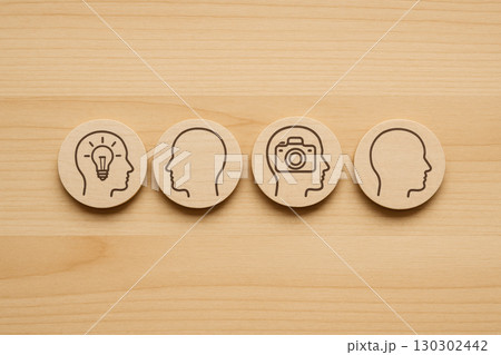 Creative thinking and innovation concept are symbolized by unique thinking and leadership idea icons representing human mind symbol in simple wooden design 130302442