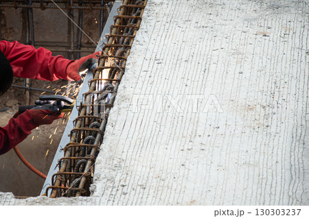Welders are welding steel at a construction site. 130303237