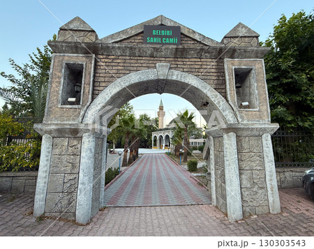 Stone entrance arch with sign leading to mosque courtyard. Religion, Islamic culture, and traditional architecture in historic urban environment. Stone entrance arch with sign leading to mosque courtyard. Religion, Islamic culture, and traditional architecture in historic urban environment. 130303543