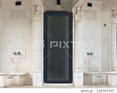 Marble ablution fountains with decorative patterns near mosque entrance. Religious tradition, ritual purity, and cultural architecture in Islamic context. Marble ablution fountains with decorative patterns near mosque entrance. Religious tradition, ritual purity, and cultural architecture in Islamic context. 130303545