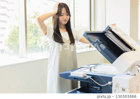 コピーをとる女性社員 130303866