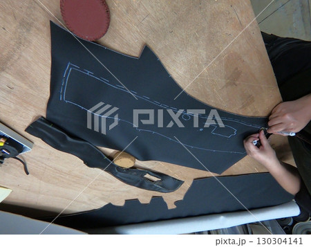 Cutting and preparing black leather or synthetic material for custom car interior 130304141