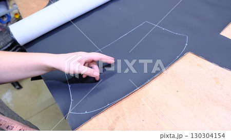 Cutting and preparing black leather or synthetic material for custom car interior 130304154
