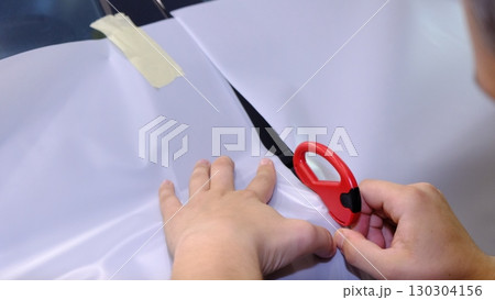 Cutting and preparing black leather or synthetic material for custom car interior Cutting and preparing black leather or synthetic material for custom car interior 130304156