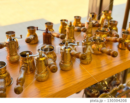 Copper and brass Turkish coffee pots with engraved designs. Traditional coffee preparation, cultural heritage, and artisanal craftsmanship. 130304208