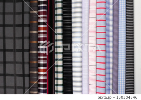 Display of various patterned fabrics in a fabric store with vibrant colors and textures 130304546