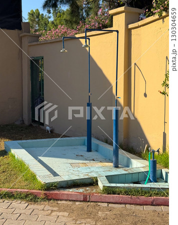 Outdoor shower near swimming pool. Vacation, refreshment, and summer relaxation. 130304659