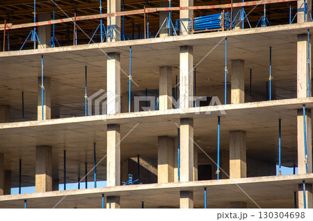 Construction progress on modern building with concrete structure and scaffolding support 130304698