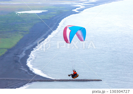 Paragliding over Iceland's stunning coast on a clear day with vibrant parachute colors Paragliding over Iceland's stunning coast on a clear day with vibrant parachute colors 130304727