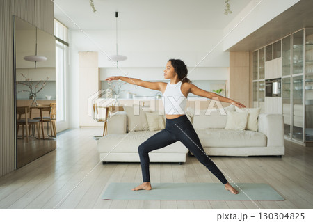 Yoga fitness workout training. Healthy African girl practicing yoga at home. Woman training Pilates doing sports exercise on yoga mat indoor. Girl have training workout for weight loss. Sport fitness Yoga fitness workout training. Healthy African girl practicing yoga at home. Woman training Pilates doing sports exercise on yoga mat indoor. Girl have training workout for weight loss. Sport fitness 130304825