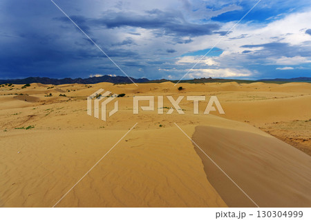 Sand dunes with storm clouds at sunset 130304999
