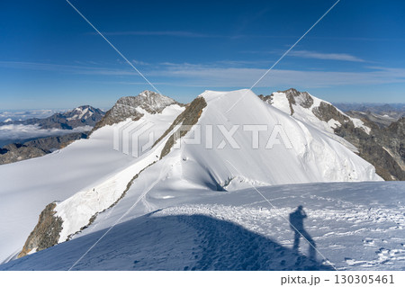 Piz Palu stands tall amidst the Swiss Alps, showcasing a vast expanse of icy glaciers and rugged peaks under a clear blue sky. Perfect for alpine adventures and photography. Piz Palu stands tall amidst the Swiss Alps, showcasing a vast expanse of icy glaciers and rugged peaks under a clear blue sky. Perfect for alpine adventures and photography. 130305461
