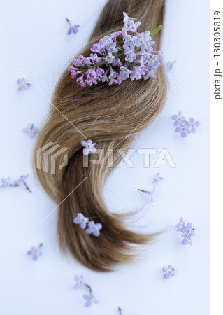 Hair with lilac flowers. Closeup, selective focus. Hair with lilac flowers. Closeup, selective focus. 130305819